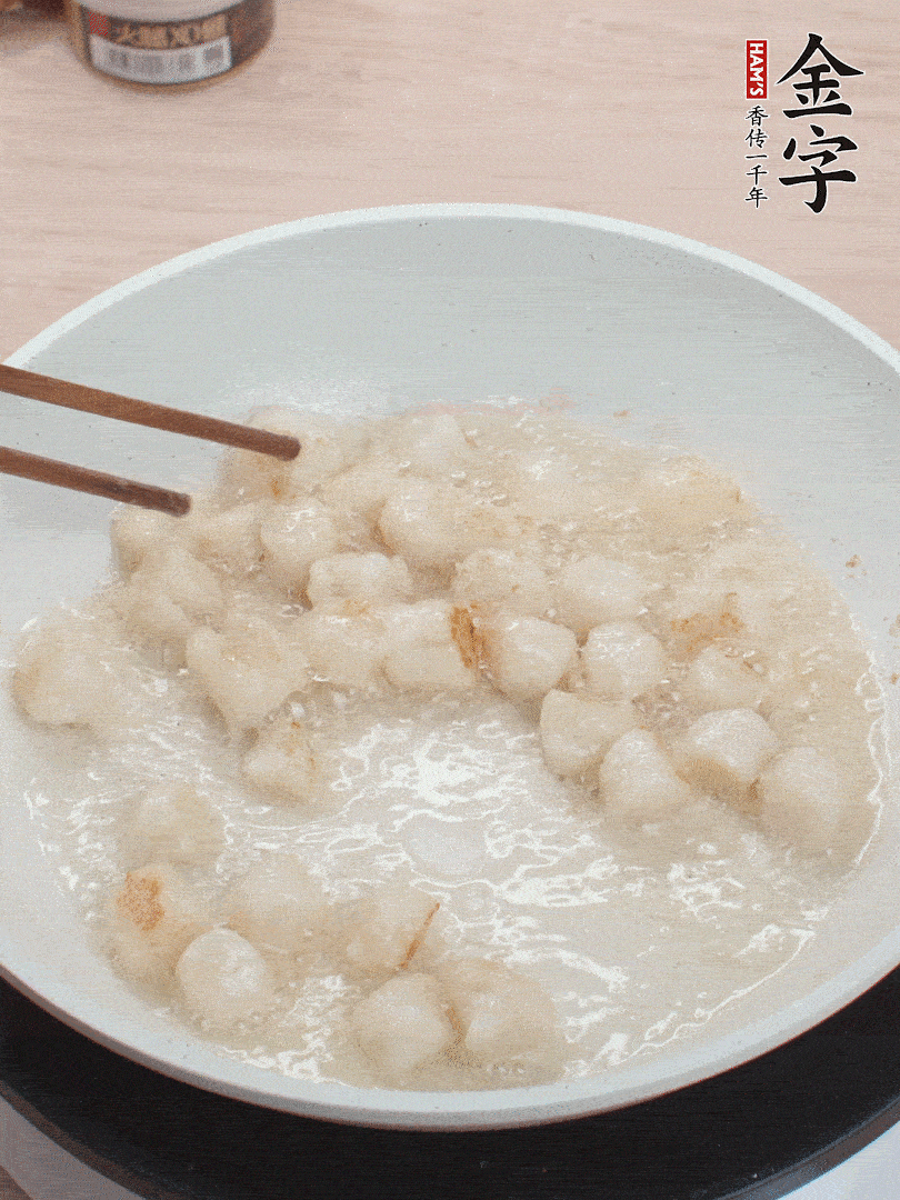 油溫4成熱，鮮貝蘸干淀粉下鍋煎，一面微黃后翻面。