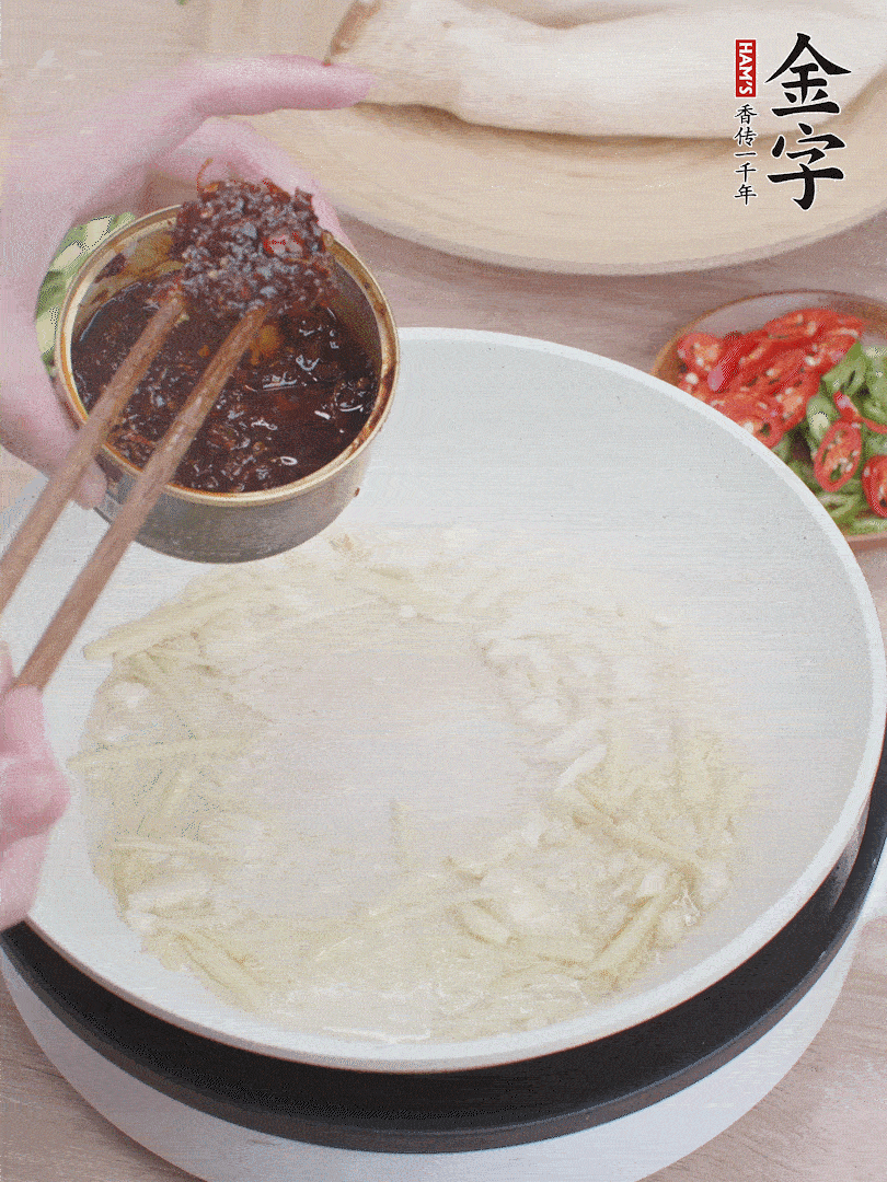 起鍋熱油，姜蒜、金字火腿干貝醬煸香。