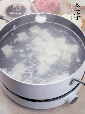 豆腐切成大小均勻正方體，鍋內(nèi)放水，加一點鹽焯水10秒。