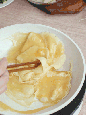 油6成熱時(shí)，下雞蛋液，邊緣凝固時(shí)翻拌成塊狀。