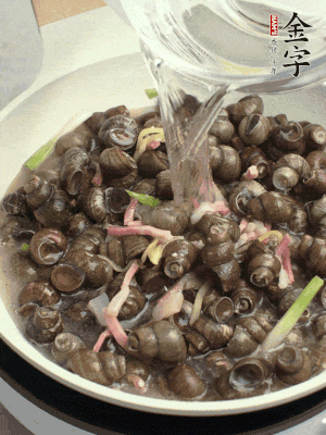 倒處理干凈的螺螄翻炒，加3勺料酒。加清水蓋過螺螄，中火蓋蓋煮5分鐘。