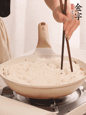 把瀝干水分的米飯均勻鋪在上面，筷子戳幾個(gè)洞，以便透氣，轉(zhuǎn)小火蓋上蓋子燜至水分收干，大概10分鐘。